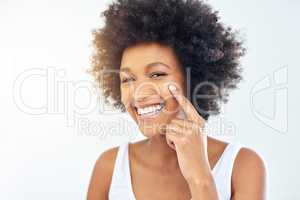 Moisturizing in the morning protects my skin the entire day. an attractive young woman applying moisturizer on her face in the bathroom at home.