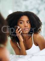 This pimple is so stubborn. an attractive young woman squeezing a pimple on her face at home.