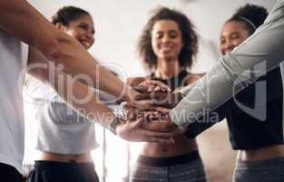 Good health is everyones responsibility. a group of young people joining their hands together in solidarity at a gym.