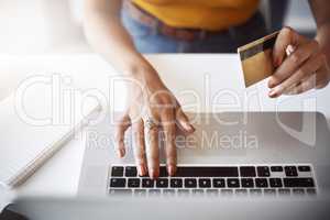 Now I can purchase anything I need easily. High angle shot of an unrecognizable female designer shopping online in her home office.