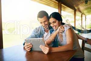 What can we binge on today. an attractive young married couple using a tablet together at home.