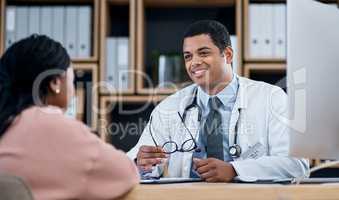 Doctor talking to patient about medical diagnosis or healthcare at an appointment or inside a clinic office. Smiling professional male physician giving good advice to client in checkup consultation