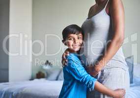 My heart has room for one more. Cropped portrait of an adorable little boy standing against his mothers pregnant belly.