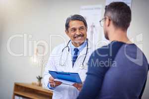 Youll be feeling better in no time. a cheerful mature male doctor consulting a patient while standing inside a hospital during the day.