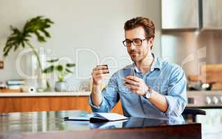 Settling his household bills in just a few minutes. a handsome young man using a cellphone and credit card at home.