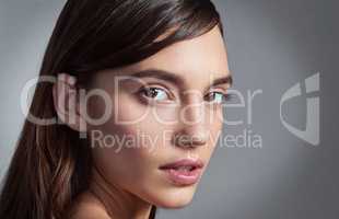 Shes a sight to behold. Studio portrait of a beautiful young woman posing against a gray background.