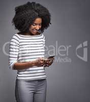 Good textiquette. She knows how its done. Studio shot of a young woman using a mobile phone against a gray background.