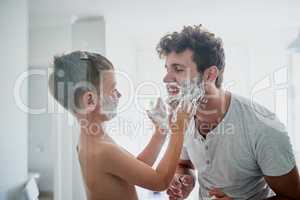 Taking playtime to the bathroom. a father teaching his little son how to shave in the bathroom at home.