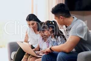 Exploring the world online as a family. a family using a laptop together at home.