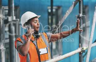 Construction worker talking on a phone call while standing in an empty building. Professional builder discussing plans and strategy, checking the inside structure. Civil engineer doing a safety check