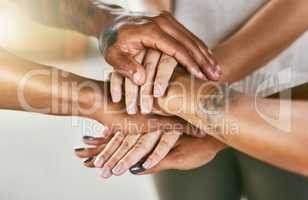 Lets work together to grow together. Closeup shot of a group of people joining their hands in a huddle.