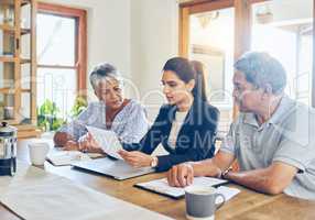 Shes going to help them make their savings last. a mature couple getting advice from their financial consultant at home.