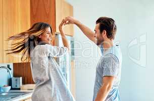 Now give me a big twirl. a happy young couple dancing together at home.