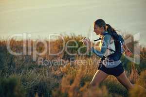 Im going to make it till the end. a young woman out for a run along a mountain trail.