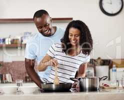He fell in love with her first, then her cooking. a young married couple cooking together in the kitchen at home.