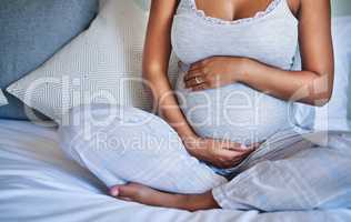 Love starts in the womb. a pregnant young woman relaxing on the bed at home.