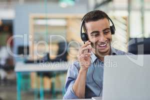 He knows how to put his customers at ease. a young call centre agent working in an office.