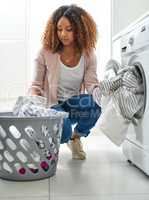 Its a chores type of day. a young attractive woman doing laundry at home.