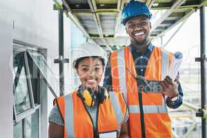 Happy and proud African American engineers at a construction site planning a building together. Portrait of young contractors standing at an apartment to be renovated for a project together