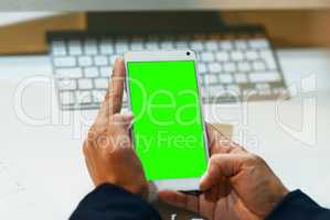 Organize your workday the smart way. Closeup shot of an unrecognizable businesswoman using a cellphone with a green screen in an office.