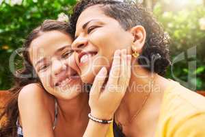 Bonding with mom. Cropped portrait of an adorable young girl and her mother embracing in the park.