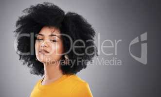 Boldly beautiful. Studio shot of an attractive young woman posing against a grey background.