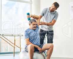 Talk me through how it feels. a young male physiotherapist assisting a senior patient in recovery.