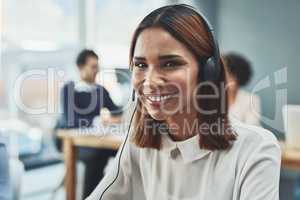 Customer service, IT support or call center agent helping and assisting on a call using a headset. Portrait of a young female sales assistant or secretary smiling while working in a modern office