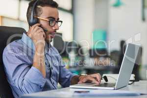 Please hold while I attempt to resolve the issue. a young call centre agent working in an office.