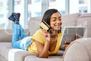Discovering online shopping and how it works. a teenage girl using a tablet and credit card at home.