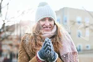 Trying to warm up my hands. Portrait of an attractive young woman enjoying being out in the snow.