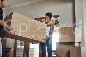 Home owner couple moving boxes into new home looking cheerful or excited inside their real estate house or living room space. Newly married first time property buyer carrying household items together