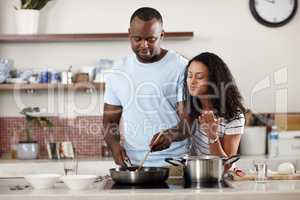 Something smells oh so delicious. a young married couple cooking together in the kitchen at home.