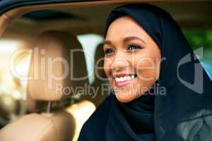 She has a bright day ahead of her. a cheerful young businesswoman getting out of a car to get to work during the day.