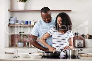 Home is where the love is. a young married couple cooking together in the kitchen at home.