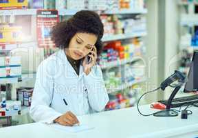 Sure, Ill have that ready for you. an attractive young female pharmacist working in a pharmacy.