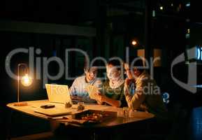 Completing tasks as a team. businesspeople working together on a digital tablet in an office at night.