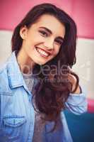 Try to be happy in every moment. Portrait of a beautiful young woman posing against a wall outside.