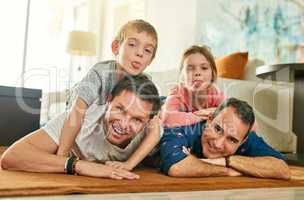 Theres always time for family. Full length portrait of an affectionate family of four lying on their living room floor.