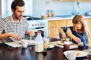 Breakfast time is bonding time for them as well. a father and his little daughter having breakfast together at home.