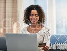 Im choosing the express delivery option. an attractive young woman making payments online with a credit card.
