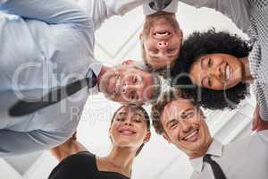Were a team of close knit colleagues. Low angle portrait of a group of businesspeople huddled together in solidarity.
