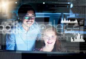 Codes and computers are part of their lives. Portrait of two focussed young programmers working together on a computer in the office at work during the night.