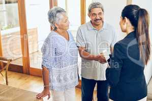 Here to help make your golden years the best years. a mature couple meeting with their financial consultant at home.