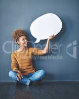 Smiling woman holding a blank white speech bubble and copyspace. Lady looking at an empty cut out to announce a sale or marketing concept. Female voice opinion on a social media chat display