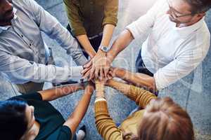 Teamwork, hands in a huddle and working together with a team or group of business people and colleagues standing in the office. Togetherness, unity and motivation between creative coworkers at work