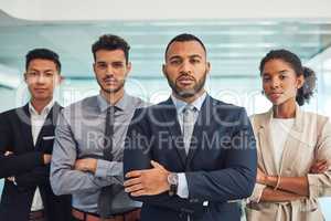 They are the best candidates for the job. Portrait of a group of confident young businesspeople standing with their arms folded inside of the office at work during the day.
