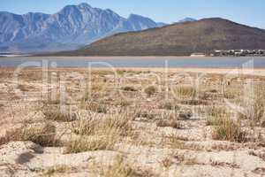 Looks like it has come down to this. a desolate landscape during the day with a small dried out dam in the middle.