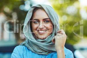 Happy to be travelling somewhere new. Portrait of a young beautiful woman wearing a headscarf outside.