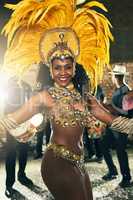 Dancing to the beat of Brazil. Cropped portrait of a beautiful samba dancer performing at Carnival with her band.